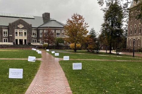 Posters line the sidewalk in the quad with facts about hunger and homelessness