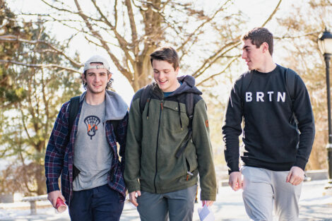 Three students walk on the Quad.