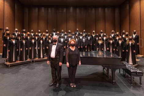 Concert Choir poses on risers with the conductor