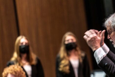Conductor keeps time as singers perform