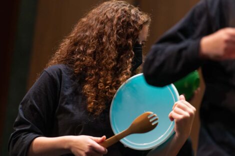 students hits plastic lid with salad fork
