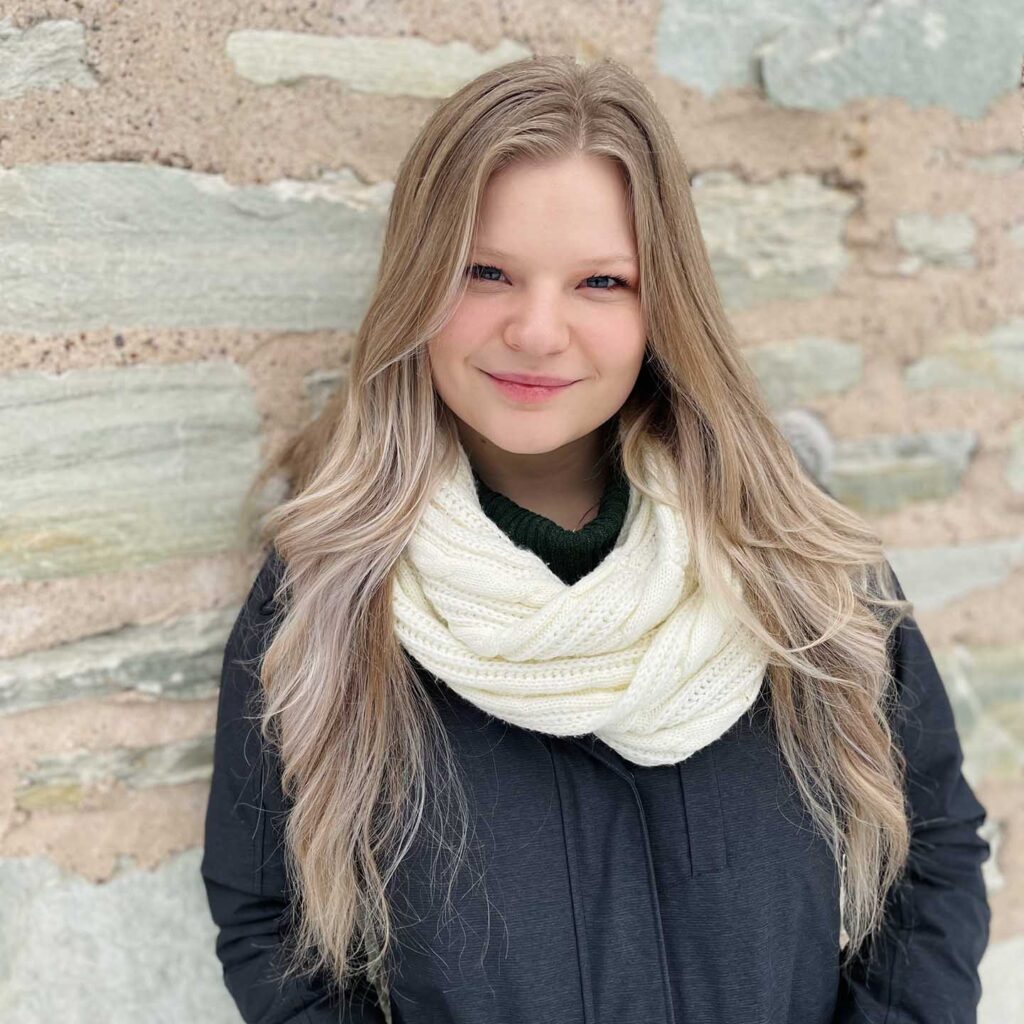 Laura Bedser wears gray coat, white scarf