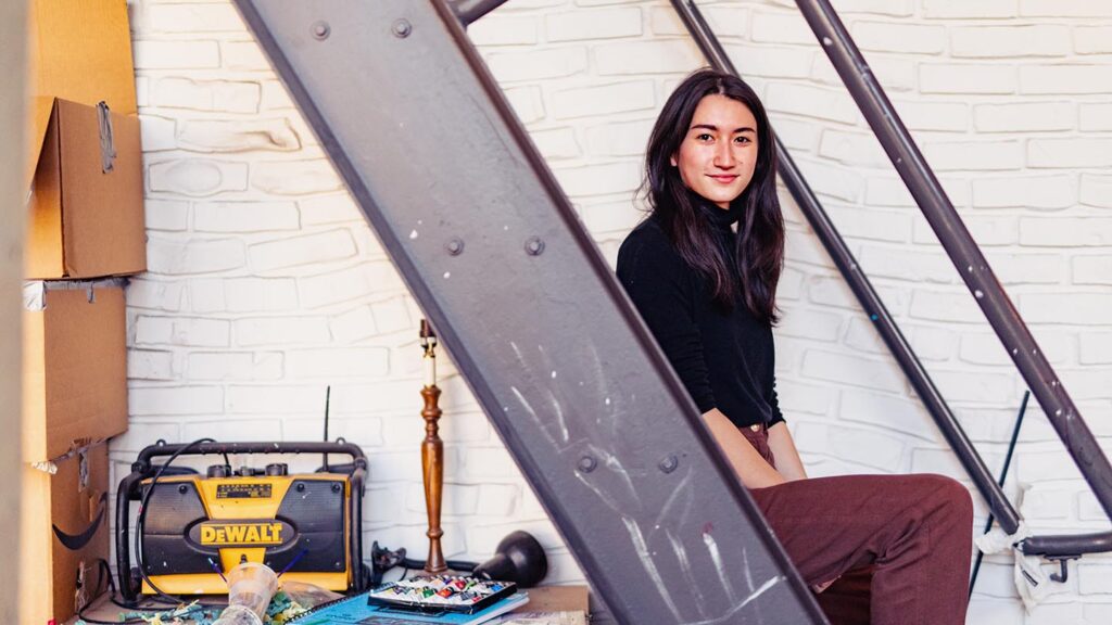 Student sits on metal stairs
