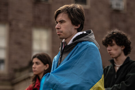 student draped in Ukrainian flag on the Quad