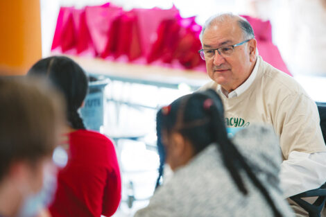 Sal Panto sits and reads a book to elementary school students
