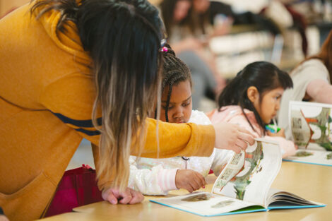 Lafayette student turns a page in a book for young student