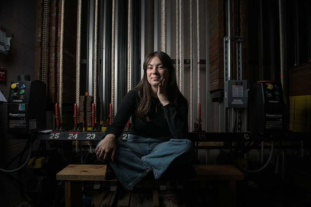 Lizzy Gumula smiles, sitting backstage.