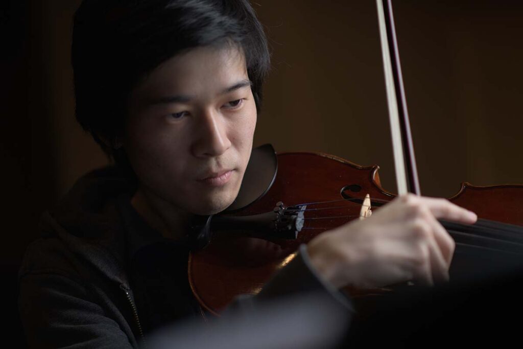 Justin plucks a string on a violin