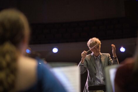 Corey looks up while conducting the opera