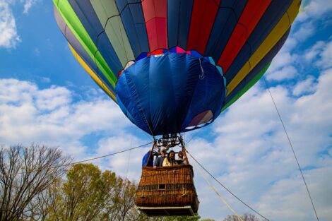 students in a hot air balloon basket are airborne