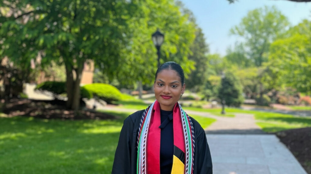 Class of 2022 valedictorian wearing graduation cap and gown on Lafayette campus