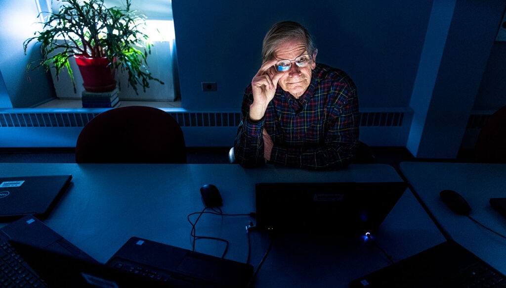 Thomas Hill smiles while holding glasses.