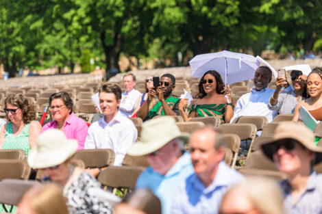 family members sit in chairs, some with umbrellas on the Quad