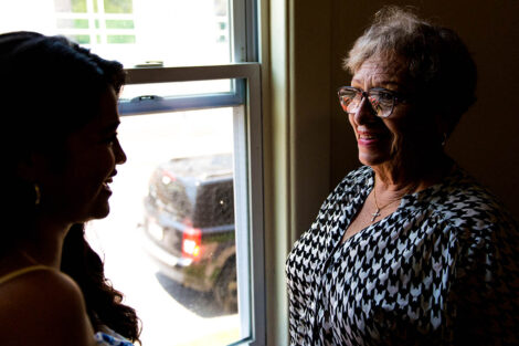 parent smiles at student, near window
