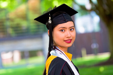 student in graduation cap smiles