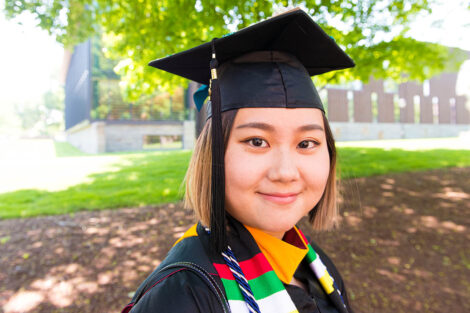 student in graduation cap smiles