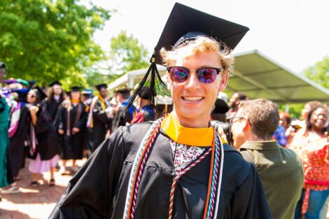 student in graduation cap smiles