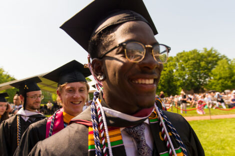 students in cap and gowns smile