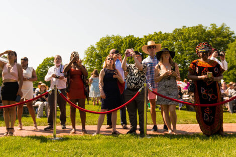 family members line up along red rope to take photos
