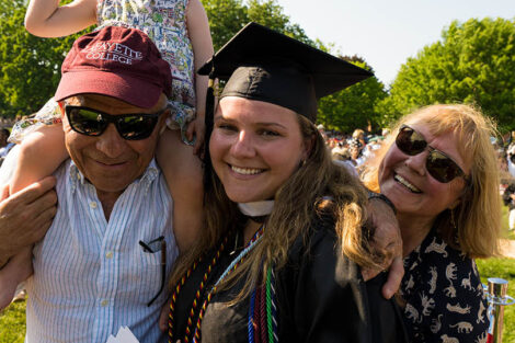 grad smiles with family members
