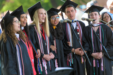 student singers sing into a microphone
