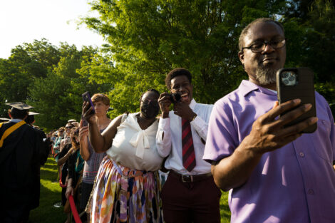 family members smile and take photos of graduates