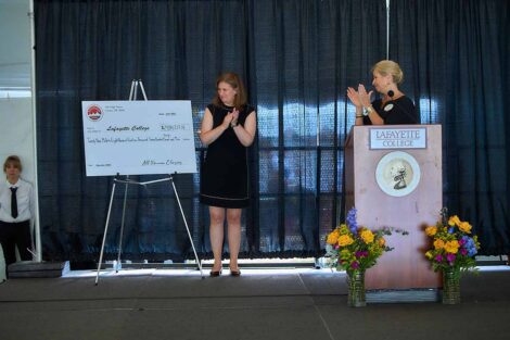 President Nicole Farmer Hurd and Tracy Haggert Sutka present a check at the Alumni Association Dinner
