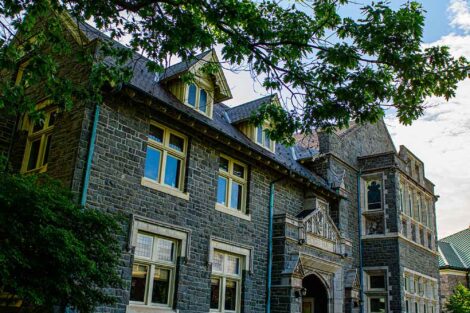 Hogg Hall is framed by green leaves
