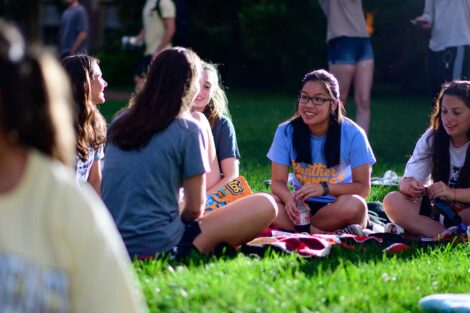 Lafayette students sitting on the lawn of the Quad and talking while awaiting the free outdoor movie screening