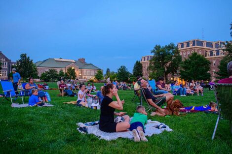 Easton community members sitting on the lawn of the Quad watching a free outdoor movie screening