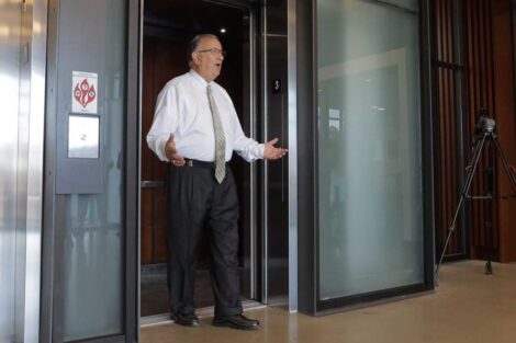 Easton Mayor Sal Panto standing in elevator doorway with surprised look as Lafayette football team surprises him with free tickets and jerseys