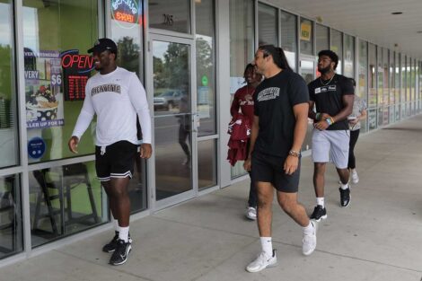 Lafayette football players walking into Picasso's pizzeria