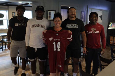 Lafayette football players posing with GOAT Pub & Pie employee
