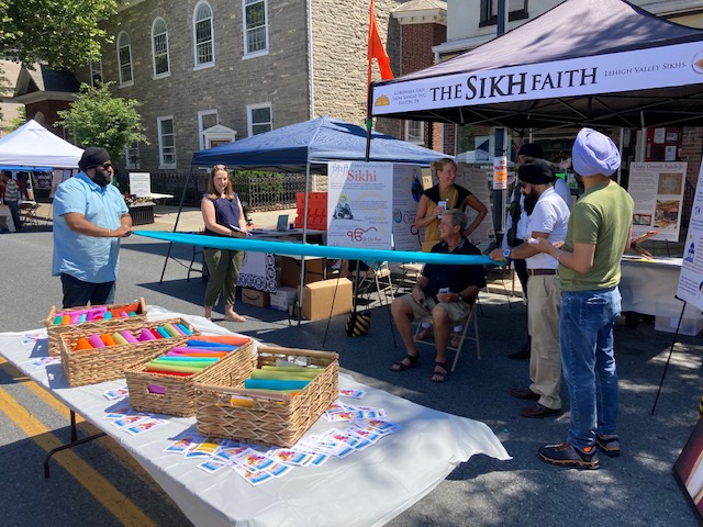 People stand around a tent set up at Festival of Faiths