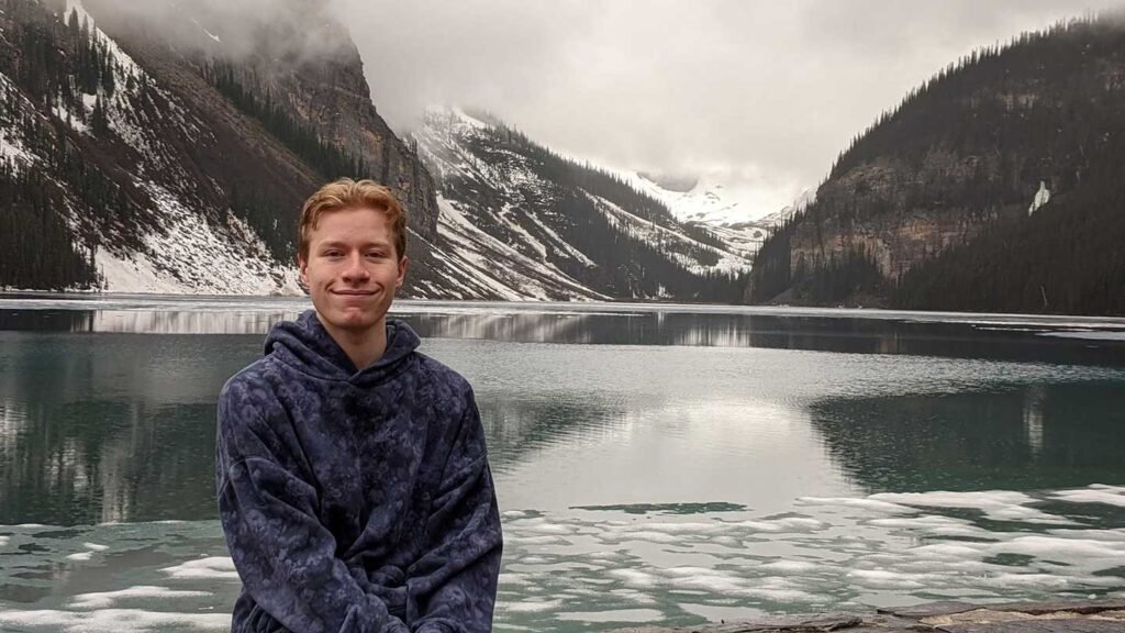 Lafayette student Jacob Potter standing outdoors in front of a background of snow-covered mountains