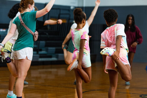 young Easton students do yoga with Lafayette students in a gymnasium