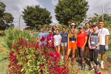 students smile in a field of wildflowers