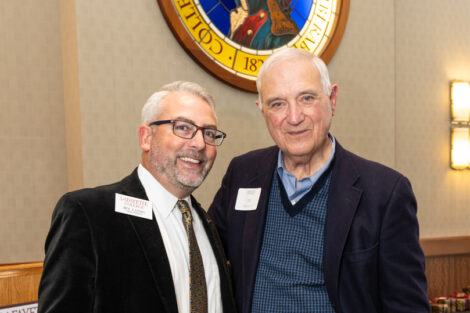 Standing under the medallion of the Marquis de Lafayette, Ben Landis and Bill Gano '57 pose for a photo.