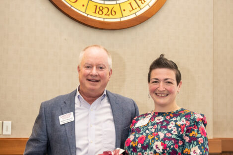 Michael Weisburger and Sara Kreisel pose smiling. Kreisel is holding a gift.