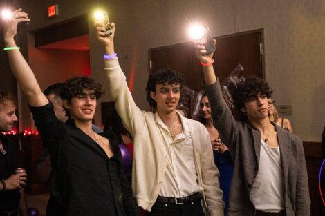 Three students hold up their phones during the Oct. 14 LGBTQIA+ formal.